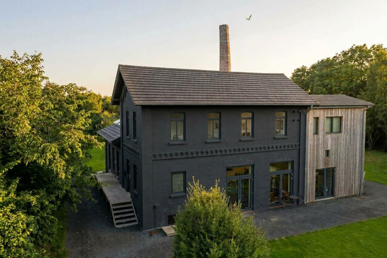 Außenansicht der Alten Meierei mit Schornstein in der Abendsonne