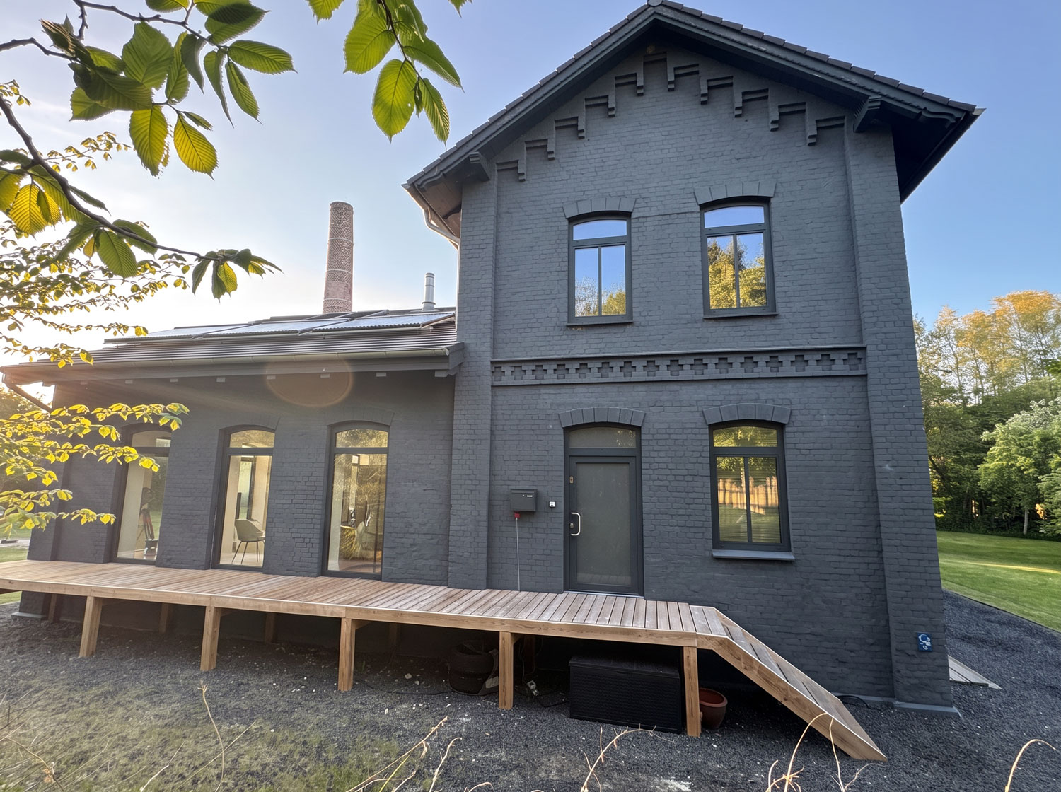 Giebelseite der Meierei mit Holzterrasse und Rampe