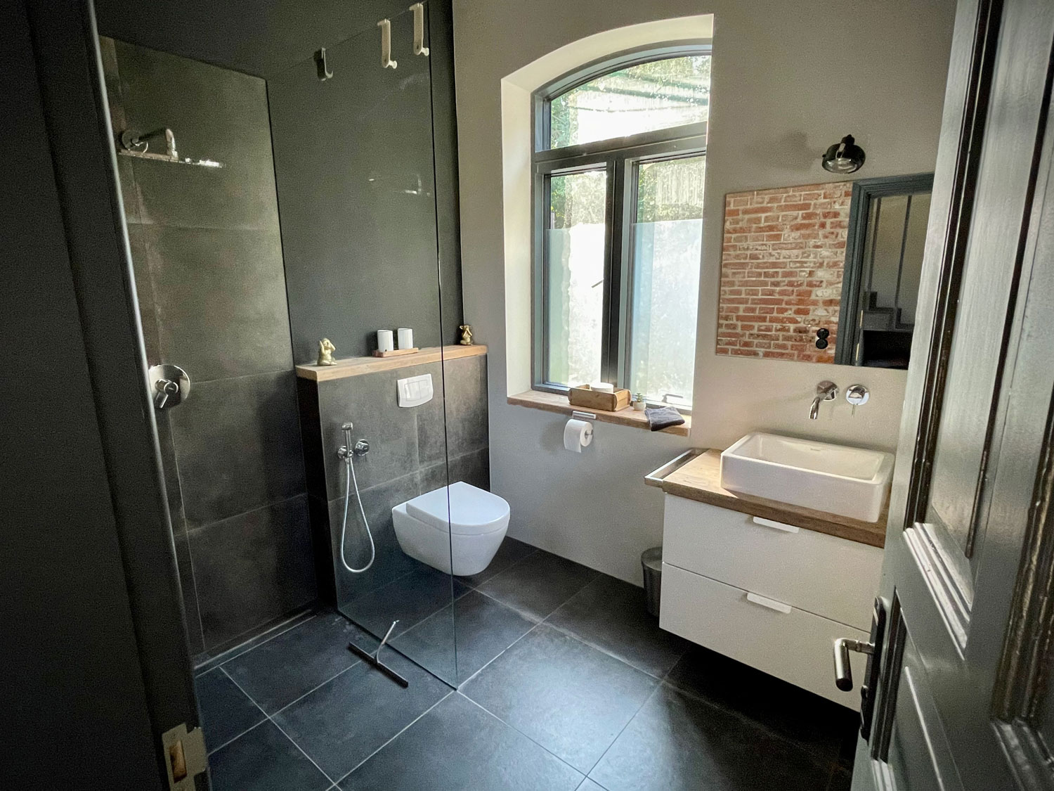 Duschbad mit bodengleicher Dusche und Bogenfenster