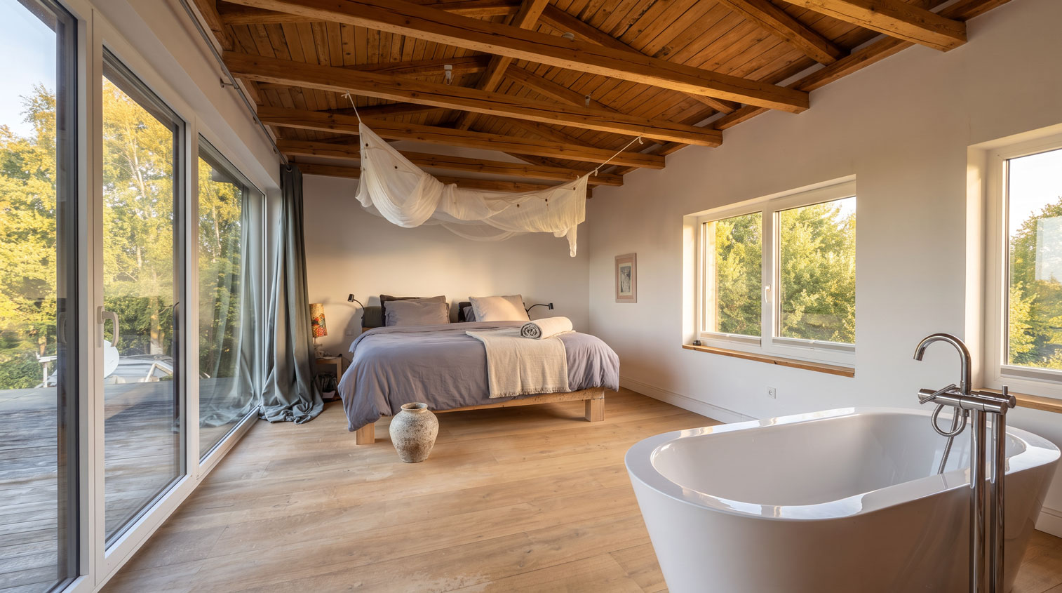 Master Bedroom mit freistehender Badewanne und Blick ins Grüne