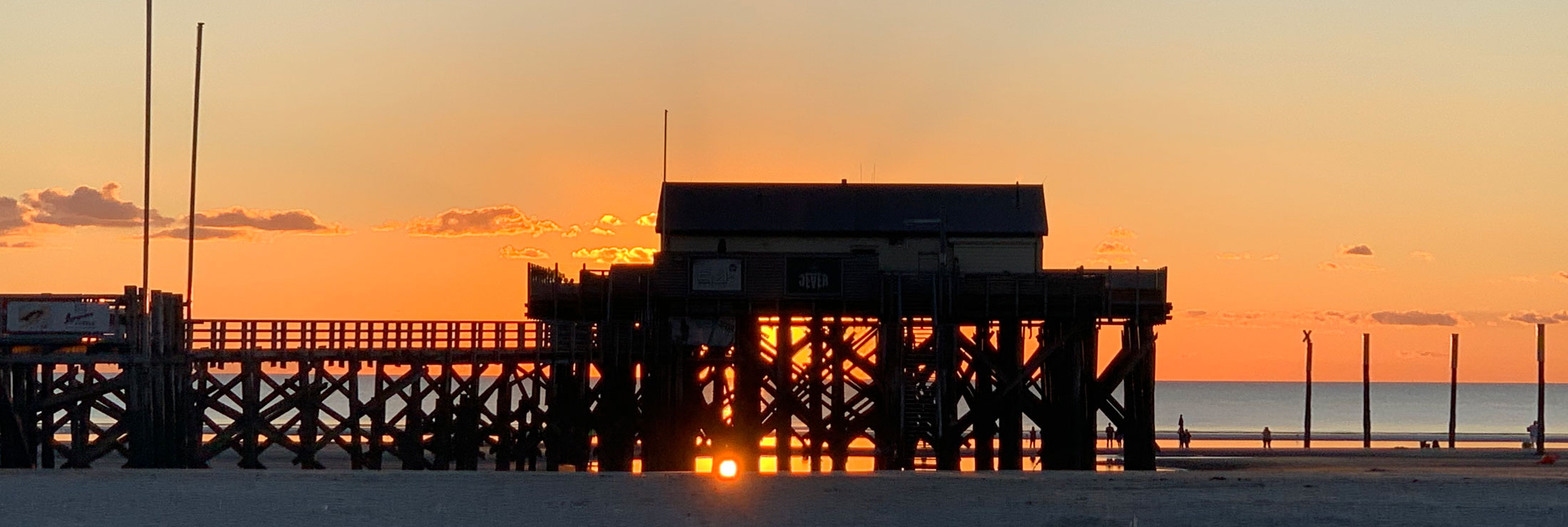 Pfahlbau in St. Peter-Ording im Gegenlicht der untergehenden Sonne